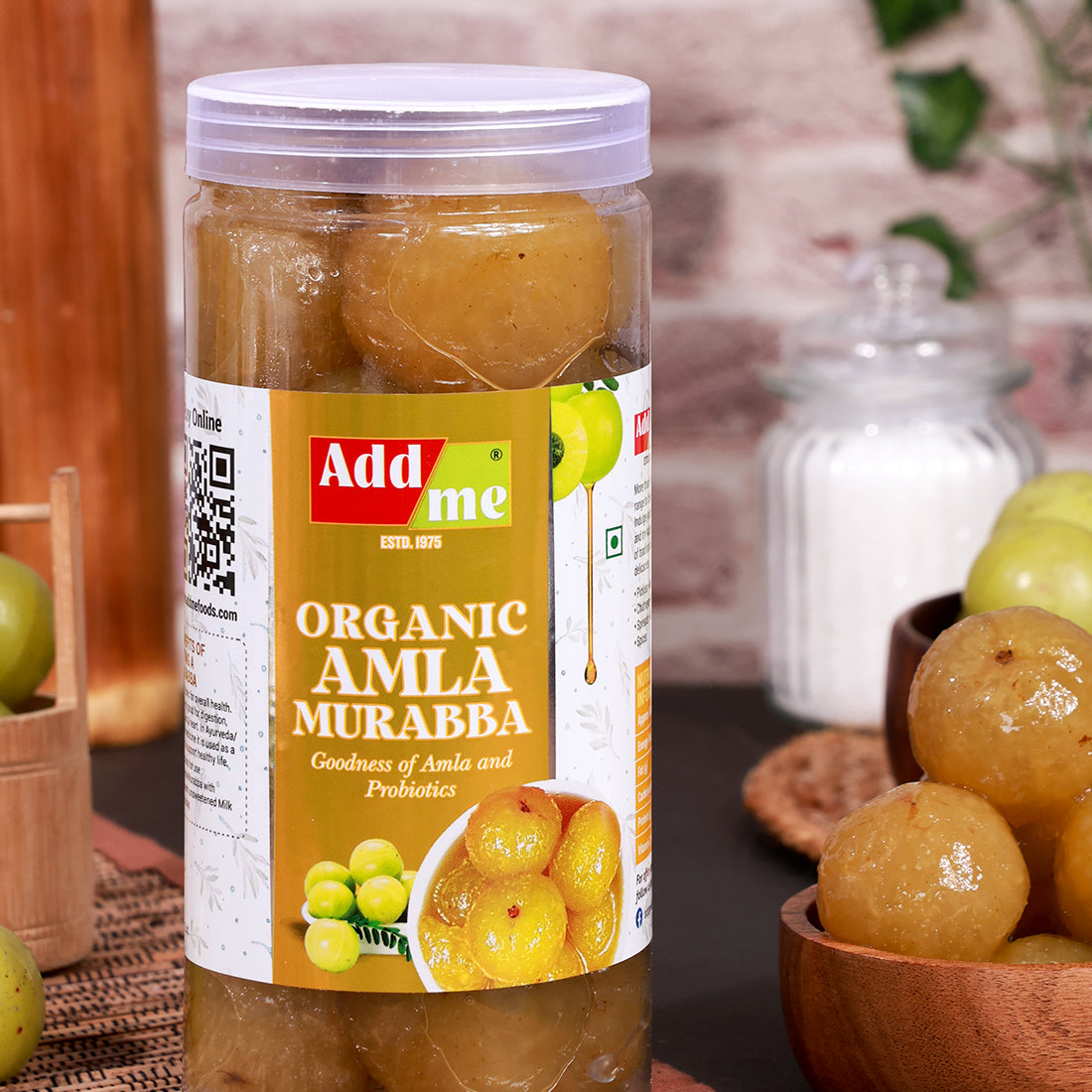 Add Me Foods: Jar of Add Me Organic Amla Murabba with a QR code on the label, surrounded by green and yellow fruits.