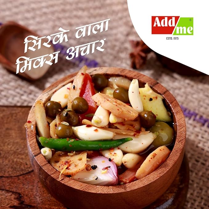 Wooden bowl of mixed pickles with spices on a textured surface, featuring Add Me brand.