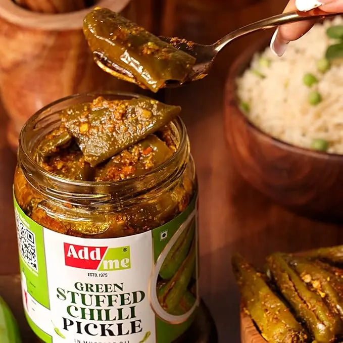 Jar of green stuffed chili pickle with a spoonful being lifted, labeled 'Add me'.