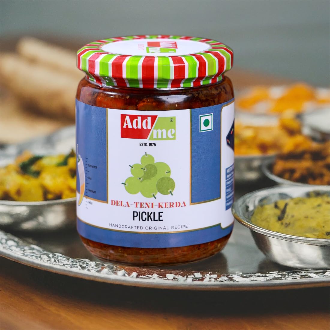 Jar of pickle with a colorful lid on a tray with food in the background