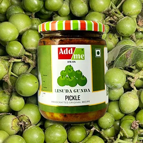 Jar of Add Me Lesuda Gunda Pickle surrounded by green fruits