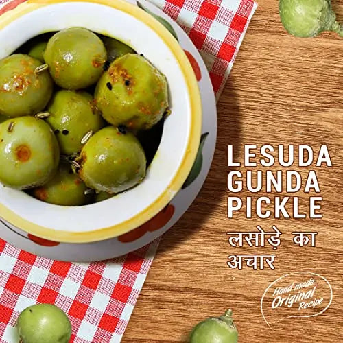 Bowl of green pickle with text 'Lesuda Gunda Pickle' on a wooden surface.