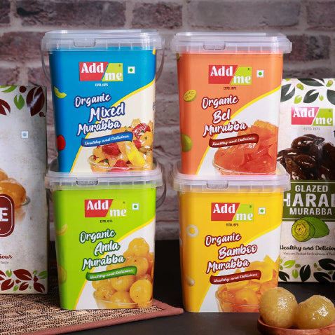 Add Me Foods: Four containers of Add me organic murabba with colorful labels on a wooden surface.