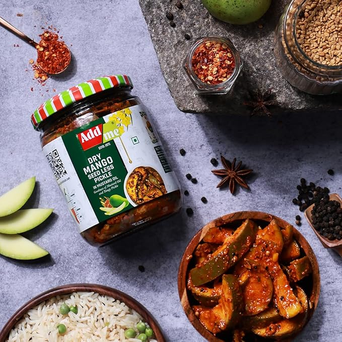 Jar of Add Me Dry Mango Seedless Pickle with ingredients on a gray surface