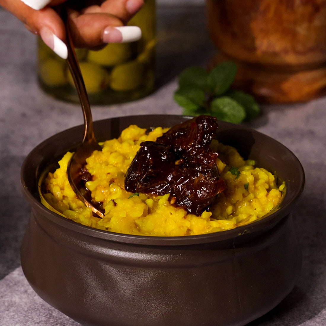 Jar of Add me Lemon Pickle with rice(Poha) on a wooden surface with ingredients in the background