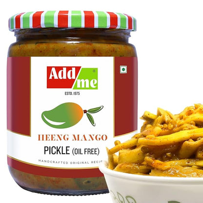 Jar of Add Me Heeng Mango Pickle with a bowl of pickles on a white background