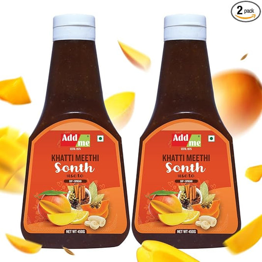 Two bottles of Add Me Khatti Meethi Sonth with mango slices on a white background