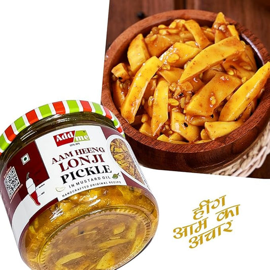 Jar of Add Me Aam Heeng Lonji Pickle with a wooden bowl of pickles on a white background