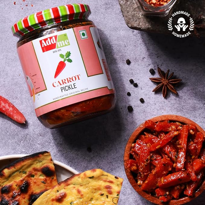 Jar of Add Me Carrot Pickle with spices and naan bread on a gray surface