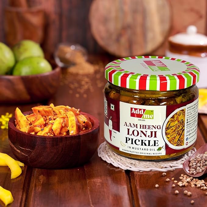 Jar of Aam Heeng Lonji Pickle with a bowl of pickled vegetables on a wooden table.