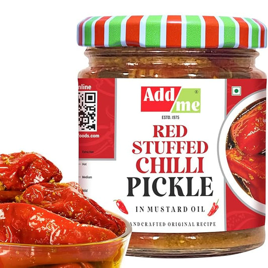 Jar of red stuffed chilli pickle with a colorful lid on a white background