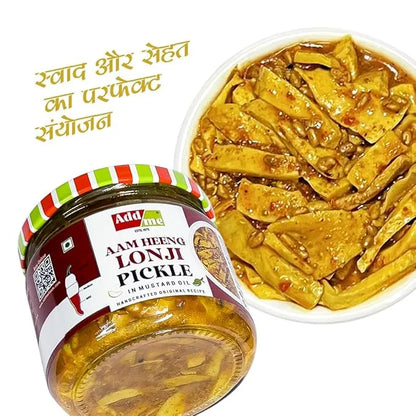 Jar of Add Me Aam Heeng Lonji Pickle with a wooden bowl of pickles on a white background