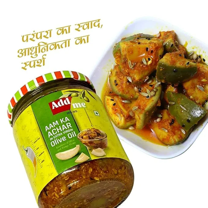 Jar of Add Me Aam Ka Achar with a plate of vegetable dish on a white background