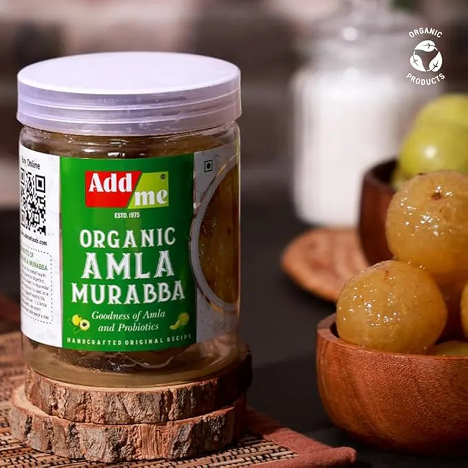 Add Me Foods: Jar of Add Me Organic Amla Murabba with a bowl of amla fruits on a wooden surface.
