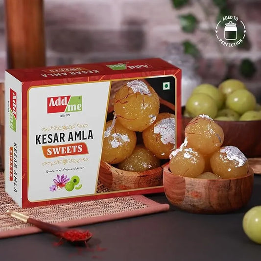 Box of Adda Me Kesar Amla Sweets with a bowl of sweets on a wooden surface. kesar amla murabba