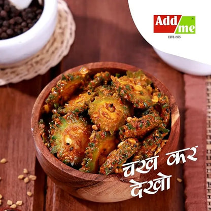 Wooden bowl of crispy okra with spices on a wooden surface, featuring AddaMe logo.
