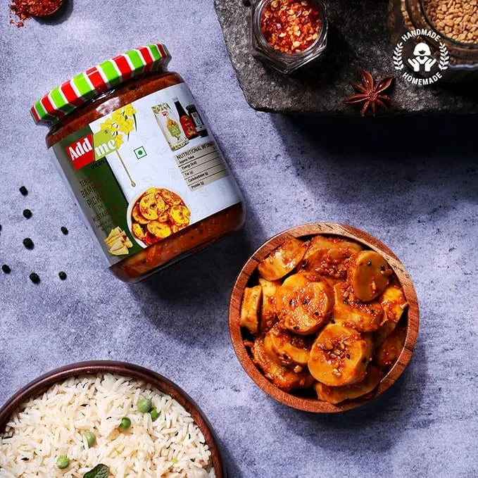 Jar of Add Aloo with a bowl of sliced potatoes in a red sauce and a bowl of rice on a gray surface.