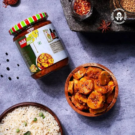 Jar of Add Aloo with a bowl of sliced potatoes in a red sauce and a bowl of rice on a gray surface.