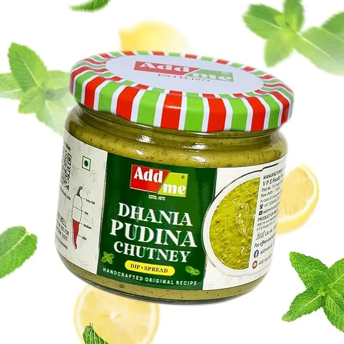 Jar of Add Me Dhania Pudina Chutney with a striped lid on a white background with mint leaves and lemons.
