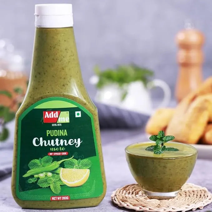 Bottle of Adda Pudina Chutney with a bowl of chutney and snacks in the background