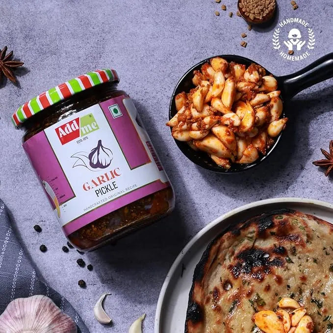 Add Me Foods: Jar of Add me Garlic Pickle with a bowl of food and flatbread on a gray surface.