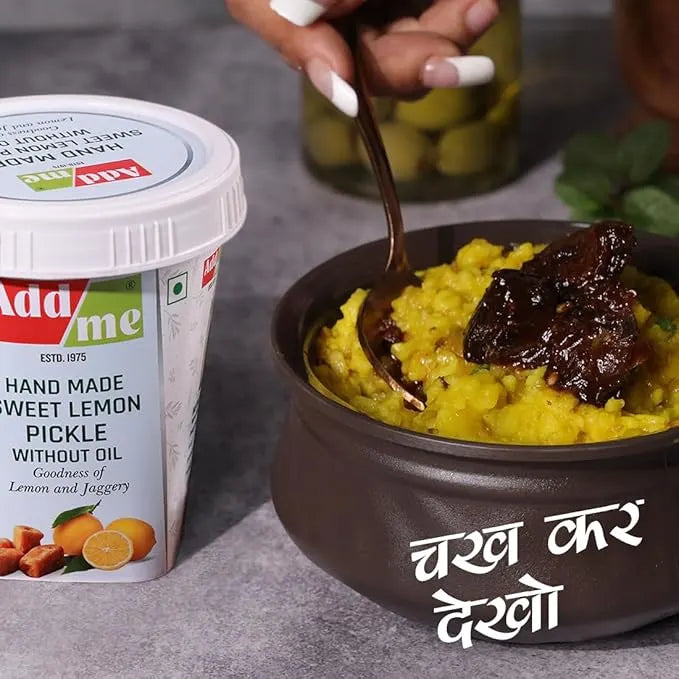 Bowl of yellow food with a dark condiment next to a container of Add Me pickle.