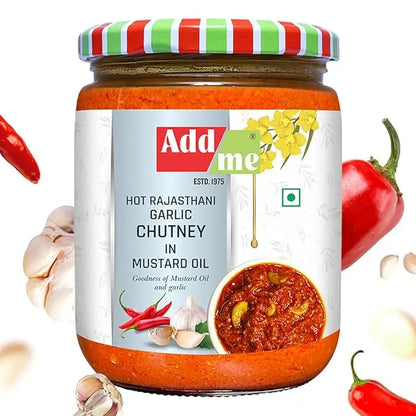 Jar of Add Me Hot Rajasthani Garlic Chutney with a colorful lid, surrounded by ingredients like garlic and red chili peppers.
