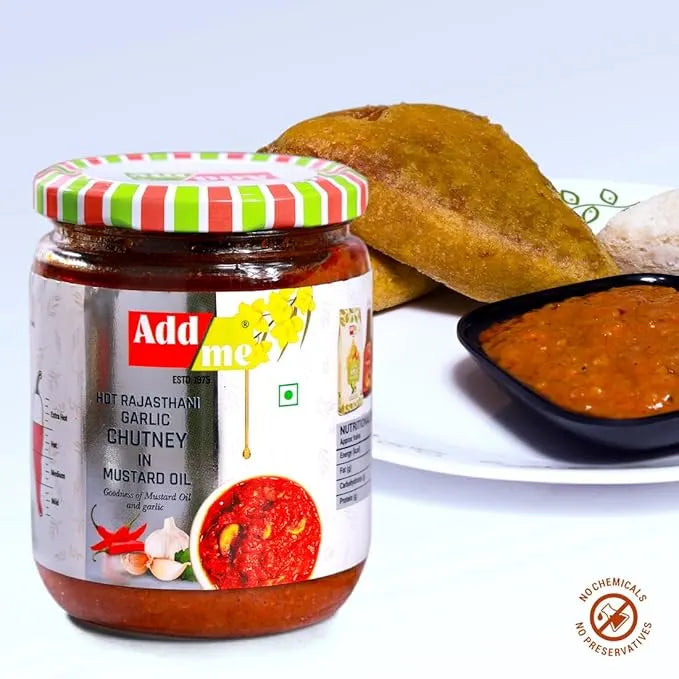 Jar of Add Me Hot Rajasthani Garlic chutney with a plate of food in the background