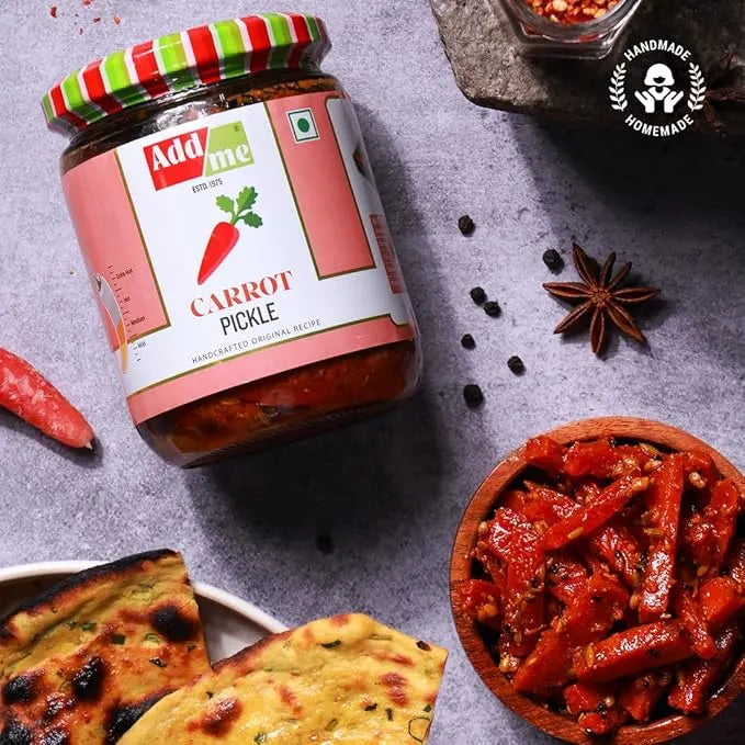 Jar of Add Me Carrot Pickle with spices and naan bread on a gray surface