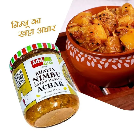 Jar of Add Me Khattha Nimbu Garam Masala Achar with a bowl of pickled fruit on a white background