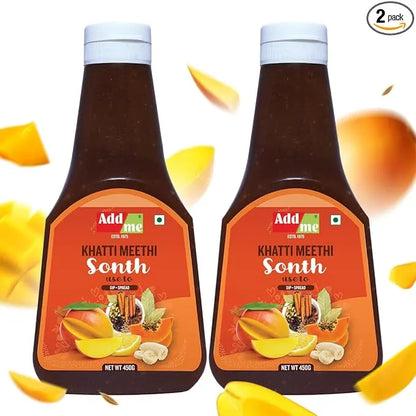 Two bottles of Add Me Khatti Meethi Sonth with mango slices on a white background. sonth chutney