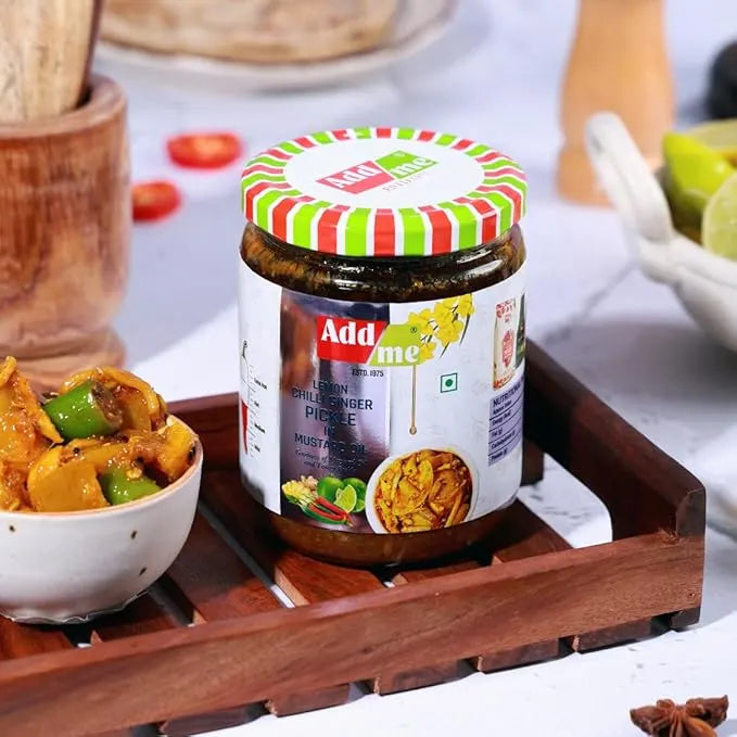 Jar of Add me pickle on a wooden tray with food in the background