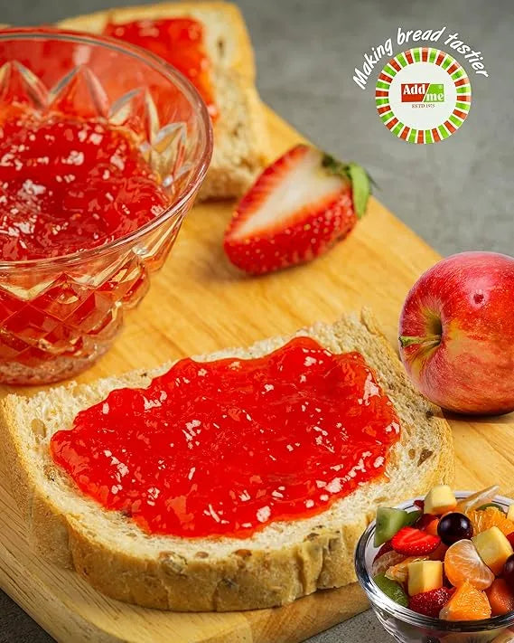 Add Me Foods: Bread with red jam, glass of red jelly, strawberries, apple, and fruit salad on a wooden board.