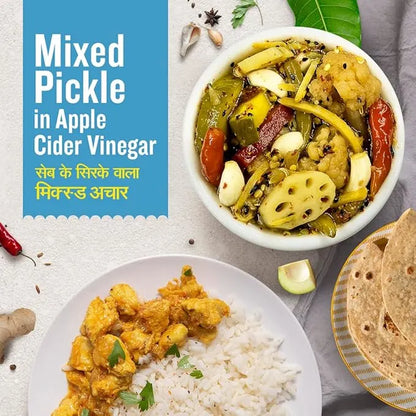 Dish of mixed pickle in apple cider vinegar with rice and roti on a white surface.