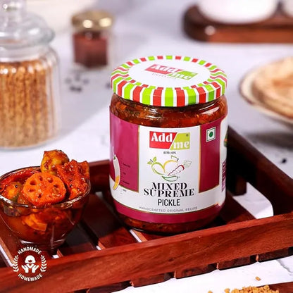 Jar of Add Me Mixed Supreme Pickle on a wooden tray with a bowl of pickles and snacks.