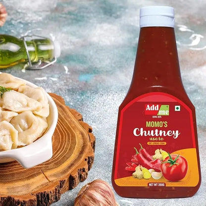 Bottle of Add me Momo's Chutney with a bowl of dumplings on a wooden board.