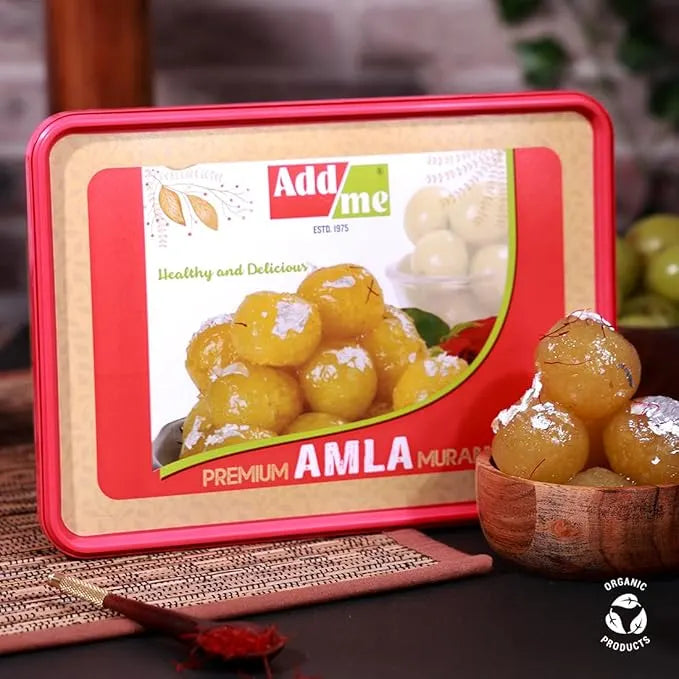 Add Me Foods: Box of Add Me Premium Amla Murabba with a bowl of amla fruits on a wooden surface.