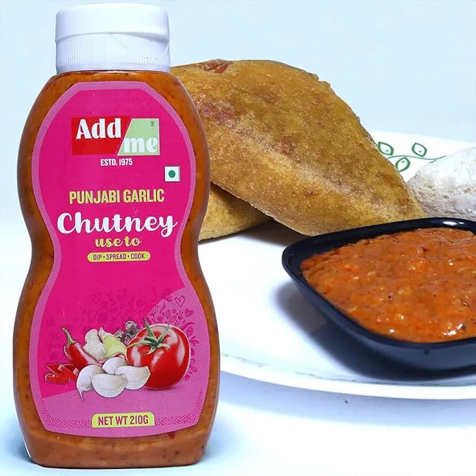 Bottle of Add Some Punjabi Garlic Chutney with a bowl of chutney and bread in the background.