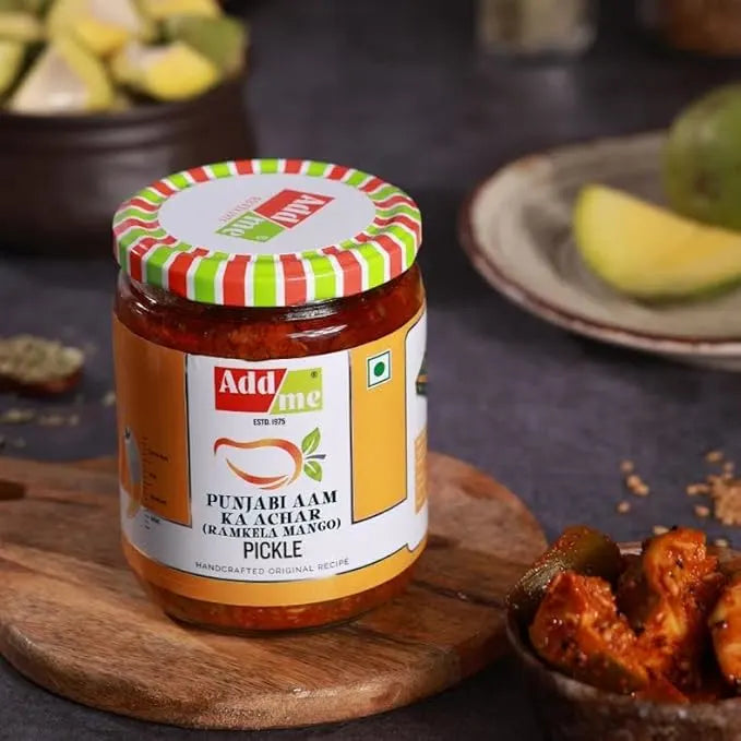 Jar of Add Some Punjabi Aam Ka Achar Pickle on a wooden board with ingredients in the background