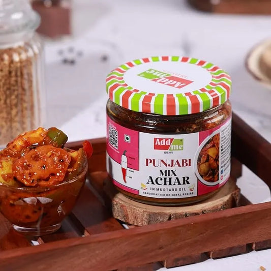 Jar of Punjabi Mix Achar with a colorful lid on a wooden tray