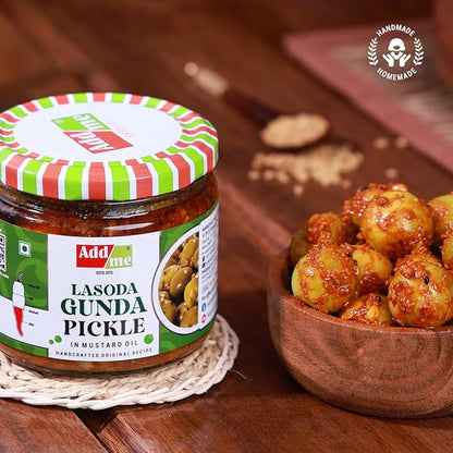 Jar of 'Add me' Lasoda Gunda Pickle with a bowl of pickles on a wooden surface