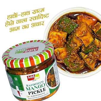 Jar of Rajasthani Mango Pickle with a bowl of pickled vegetables on a white background