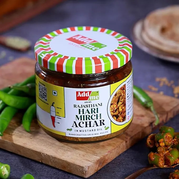 Add Me Foods: Jar of Add Me Rajasthani Hari Mirch Achar on a wooden board with green chilies and a spoonful of the pickle.
