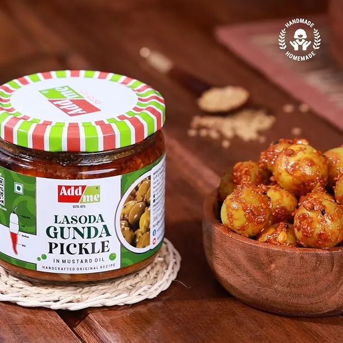 Jar of 'Add me' Lasoda Gunda Pickle with a bowl of pickles on a wooden surface