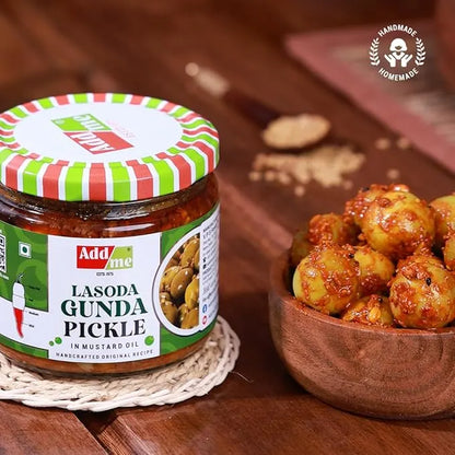 Jar of 'Add me' Lasoda Gunda Pickle with a bowl of pickles on a wooden surface