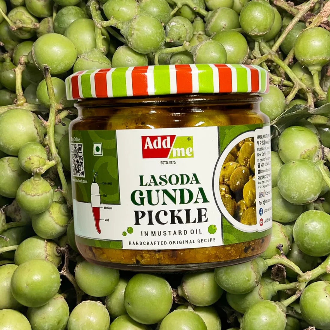 Jar of Add Me Lasoda Gunda Pickle surrounded by green fruits