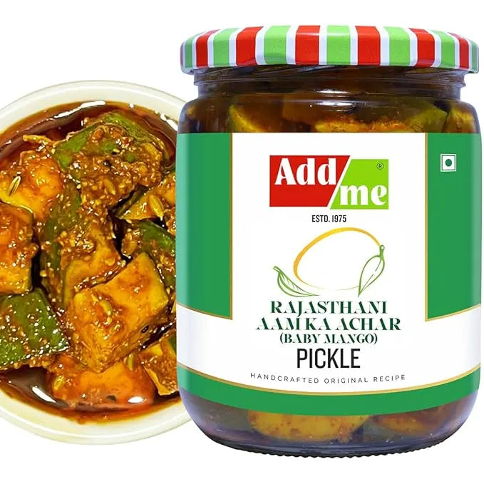 Jar of Add Me Rajasthani Aam Ka Achar pickle with a bowl of curry and green chilies.
