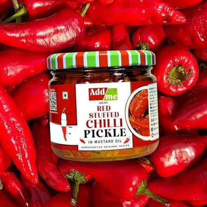 Jar of Adda Red Stuffed Chilli Pickle surrounded by red chili peppers