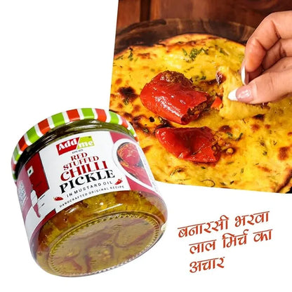 Jar of red stuffed chilli pickle with a hand holding a piece of naan with pickle on it.