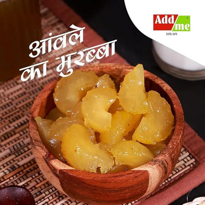 Add Me Foods: Wooden bowl filled with yellow preserved fruit (Amla) on a textured surface with 'Add Me' branding.